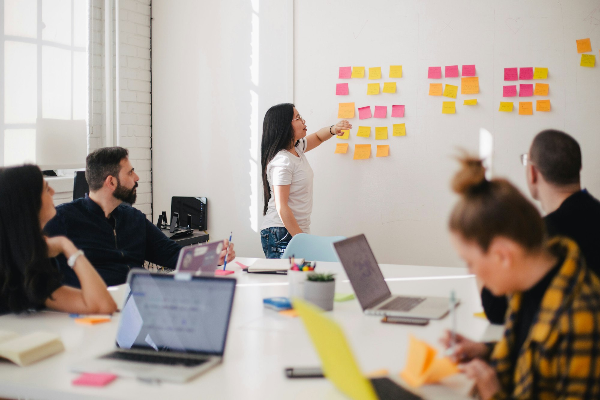 Team bespreekt een planning bij een wand met notities